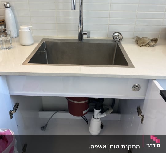 כיור מטבח עם ברז, צנרת מתחת לארון